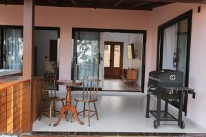 a living room with a grill and a table and chairs at Recanto Bougainville ST in Santa Teresa