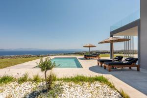 a swimming pool with two lounges and two chairs at Thalori villa 1 in Psalidi