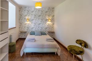 a bedroom with a bed and two chairs at Ti Coet Salio - Nature & calme près de Guerlédan in Guerlédan