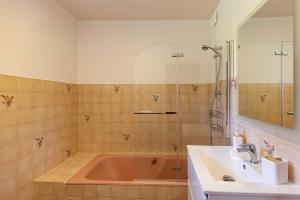 a bathroom with a red tub and a sink at Ti Coet Salio - Nature & calme près de Guerlédan in Guerlédan