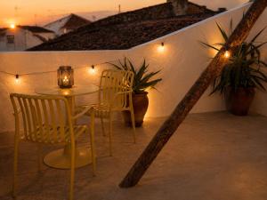 a table and chairs on a balcony with lights at Pátio 38 do frade in Aldeia do Mato