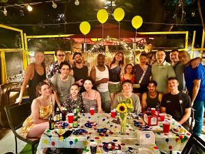 a group of people posing for a picture at a table at the Brooklyn Riviera in Brooklyn