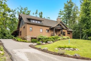 a large wooden house with a gravel driveway at Wee-Kin-Da-Wa in Boyne Falls