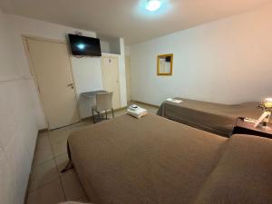 a hotel room with two beds and a flat screen tv at Hotel y Cabañas Gran Cordoba in La Falda
