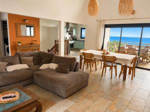a living room with a couch and a table at Kaz mer veille in Les Avirons