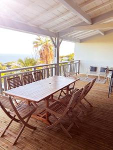 a wooden table and chairs on a deck at Kaz mer veille in Les Avirons