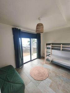 a bedroom with a bunk bed and a large window at Kaz mer veille in Les Avirons