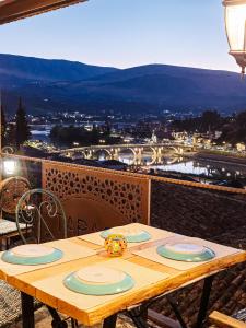 a wooden table with plates on top of a balcony at Hotel Taraca Gorice - UNESCO quarter in Berat