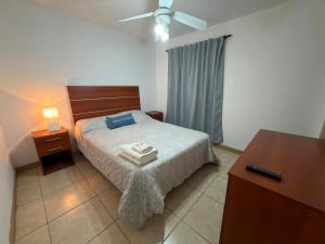 a bedroom with a bed with two towels on it at Hotel y Cabañas Gran Cordoba in La Falda