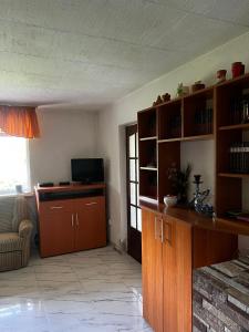 a living room with wooden shelves and a television at Casa Dany in Zărneşti