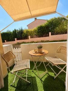 a table and two chairs and a table and chairs on a patio at Studio hesperides in Balaruc-les-Bains