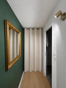a room with a mirror and a curtain at Studio hesperides in Balaruc-les-Bains