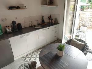a kitchen with a table and a table and chairs at La Suite 27 bis, maison de charme avec terrasse, proche gare et centre in Guingamp