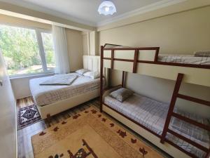 a bedroom with two bunk beds and a window at Sağlık Apart Pansiyon in Erdek