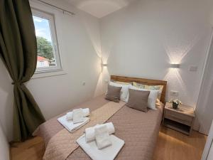a bedroom with a bed with two towels on it at NINAS Apartments in Elshani