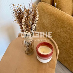 a candle and a vase on a table next to a couch at GC - Au Large - Front de Mer in Wissant