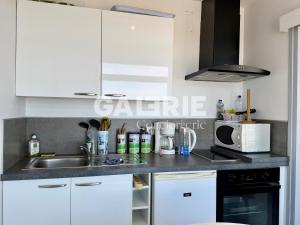 a kitchen with a sink and a microwave at GC - Au Large - Front de Mer in Wissant +16 photos