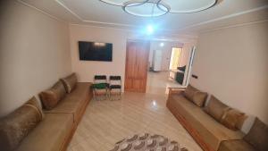a living room with a couch and a table at Appartement propre in Saïdia