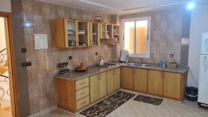 a kitchen with wooden cabinets and a sink and a window at Appartement propre in Saïdia