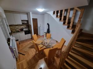 a living room with a table and chairs and a staircase at Kuća za odmor Lavanda in Sirogojno +13 photos