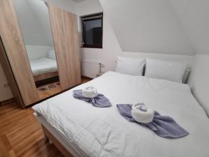 a bedroom with a bed with towels and a mirror at Kuća za odmor Lavanda in Sirogojno