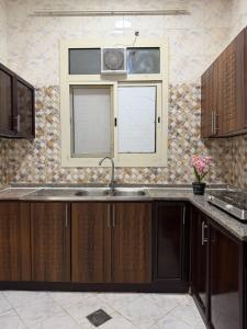 eine Küche mit Spüle und Fenster in der Unterkunft Naforah in al-Ain + 6 Fotos