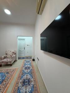 un soggiorno con un divano e un televisore a parete di Naforah a Al Ain Altre 6 foto
