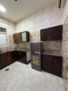 una cucina con mobili marroni e un frigorifero di Naforah a Al Ain