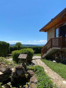 a house with a deck and a bench in the yard at Cozy Green Escape in Kakanj +5 photos