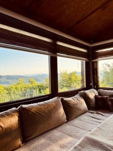 a large couch in a room with large windows at Cozy Green Escape in Kakanj