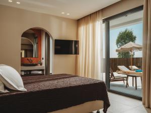 a bedroom with a bed and a balcony with a table at Serenita luxury villa in Zakynthos
