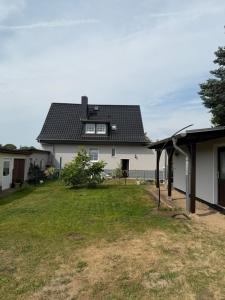 a large white house with a black roof at Strandhaus Störtebeker in Koserow +4 photos
