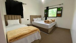 a bedroom with two beds and a window at Beldi apparemment in Imlil