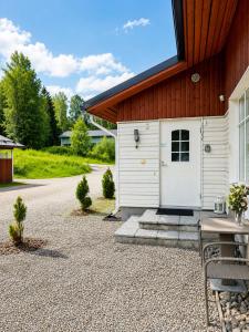 a building with a white door and a table at Kulta Villa, keskellä Vuokattia sisältyy Sauna, ilmainen Pysäköinti, Wi-Fi, 65smartTV, oma pieni piha alue, sopii perheille in Vuokatti