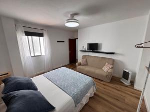 a bedroom with a bed and a couch at Casa Rosales in La Orotava