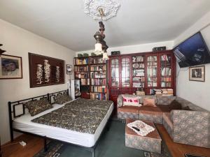a bedroom with a bed and a couch and a chandelier at Egry Rooms in Veszprém