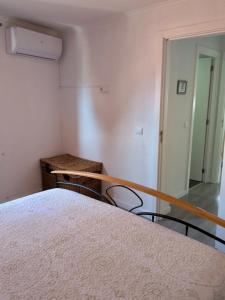 a bedroom with a bed and two chairs and a mirror at Alojamento Lazer in Folgosa