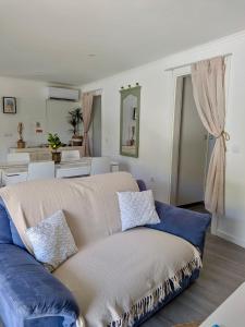 a living room with a blue couch and a kitchen at Alojamento Lazer in Folgosa +23 photos