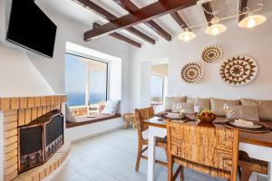 a living room with a fireplace and a dining room at Mythos Villa Above the Sunset in Karpathos