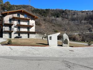 a building and a statue in front of a building at La Crevasse Morgex in Morgex