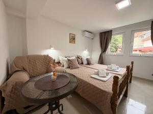 a bedroom with a bed and a table and a couch at NINAS Apartments in Elshani