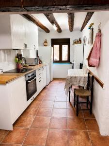 a kitchen with white cabinets and a table at Casa Josefa Xiva Morella in Chiva de Morella
