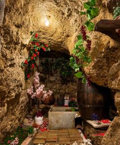 a stone cave with flowers and a large barrel at Casa Josefa Xiva Morella in Chiva de Morella +11 photos