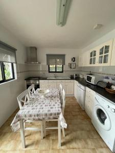 a kitchen with a table and chairs and a washing machine at Vila Estrela in Vale do Lobo