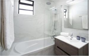a white bathroom with a sink and a shower at Vila Estrela in Vale do Lobo +13 photos