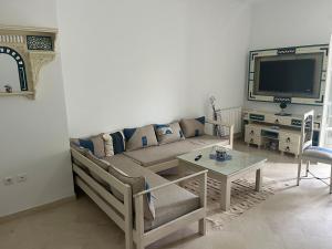 a living room with a couch and a table at Arabesque-style apartment in Yasmine