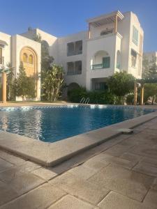 a swimming pool in front of a building at Arabesque-style apartment in Yasmine