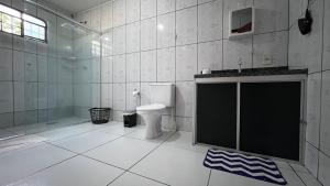 a bathroom with a toilet and a shower and a sink at Casa Lari Hostel in Vila Tepequém