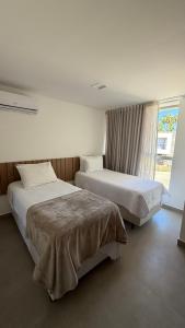 a hotel room with two beds and a window at Casa Marimar Milagres- Praia do Marceneiro in Passo de Camarajibe +39 photos