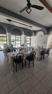 a dining room with tables and chairs and windows at Hotel barrica in Realicó